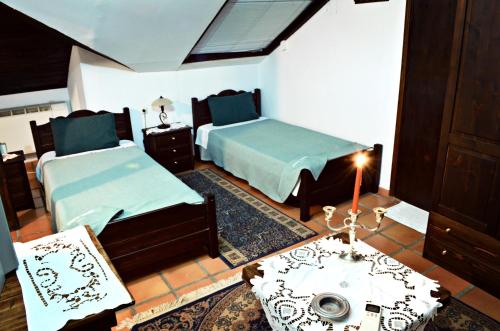 a bedroom with two beds and a table with a candle at Archontariki Guesthouse in Poligiros