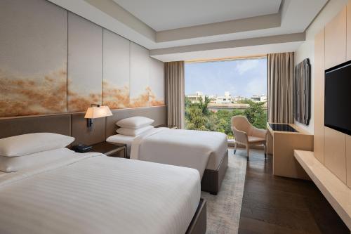 pokój hotelowy z 2 łóżkami i telewizorem w obiekcie Indore Marriott Hotel w mieście Indore
