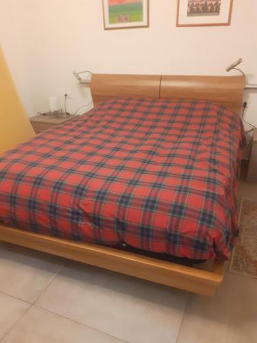 a bed with a plaid comforter in a room at B&B Daniela in Darfo