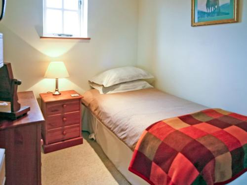 a small bedroom with a bed and a table with a lamp at 2 Bed in Stratford-upon-Avon CC025 in Ilmington