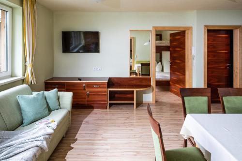 a living room with a couch and a desk at Apparthaus & Chalets Hofer in Zell am Ziller