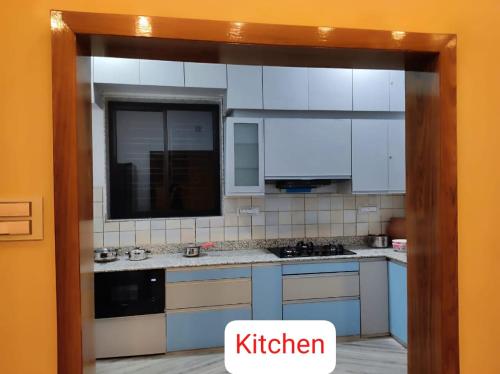 a kitchen with white cabinets and a sink and a mirror at Vedic village aqua villa 3bhk in kolkata