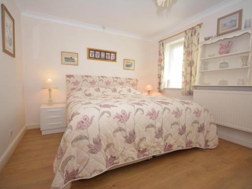 a bedroom with a bed with a floral bedspread at 1 Bed in Gilwern 52882 in Gilwern
