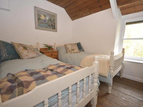 a bedroom with two beds and a window at 3 Bed in Aberaeron 55308 in Ciliau-Aeron