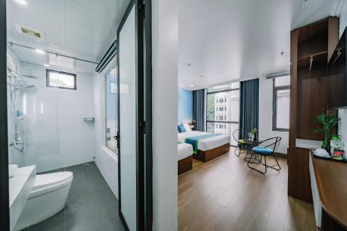 uma casa de banho com WC e um quarto com cama em TOMMY HOTEL em Ilha de Cát Bà