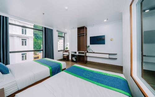 a bedroom with two beds and a large window at TOMMY HOTEL in Cat Ba