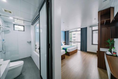 a bathroom with a toilet and a bedroom with a bed at TOMMY HOTEL in Cat Ba