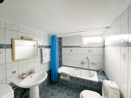 een badkamer met een bad, een wastafel en een toilet bij Nitsa Apartment in Kavala