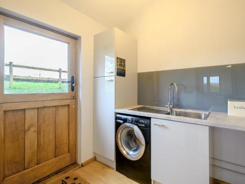 a kitchen with a sink and a washing machine at 1 Bed in Dulverton 59339 in Knowstone