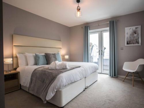 una camera da letto con un grande letto bianco e una finestra di 3 Bed in Westward Ho 60264 a Westward Ho