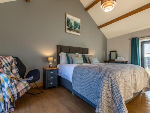 um quarto com uma cama, uma cadeira e uma janela em 5 Bed in Widemouth Bay 60490 em Clawton