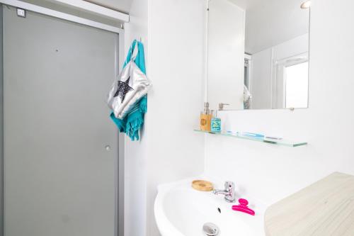 W łazience znajduje się umywalka i lustro. w obiekcie Domaine de La Marina w mieście Messanges