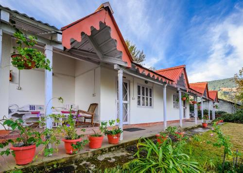 a house with a lot of plants inront of it at Neemrana's - Ramgarh Bungalows in Rāmgarh