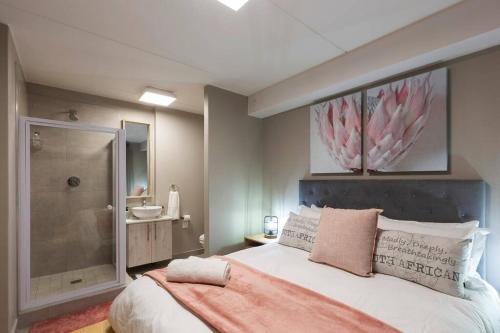 um quarto com uma cama grande e um chuveiro em Nivica 56 Luxury Apartment Langebaan em Langebaan