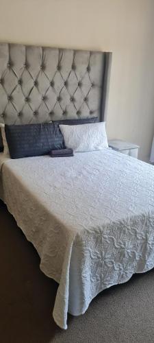 a bed with a white bedspread and pillows on it at Streetview Suites in Polokwane