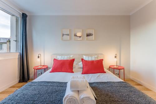 une chambre avec un grand lit avec deux oreillers rouges dans l'établissement Le Chapeau-Rouge - Au Cœur de Nantes, à Nantes