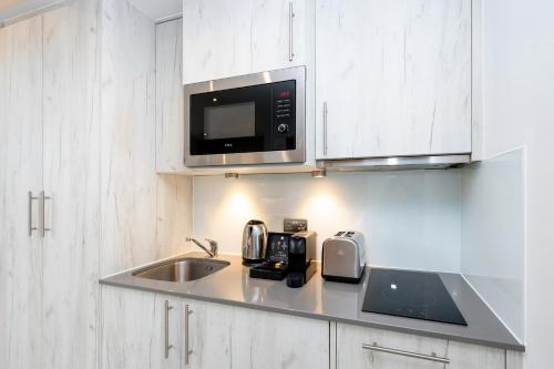 a kitchen with a sink and a microwave at Staycity Aparthotels Liverpool Waterfront in Liverpool