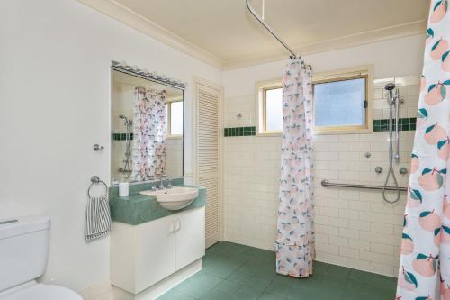 a bathroom with a sink and a shower at Rennies Beach Escape "Carinya" in Ulladulla