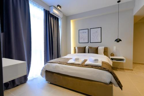 a bedroom with a large bed with two towels at Luxury Super Central Apartment 2 in Larisa