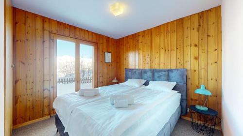 ヴェゾナにあるFontannets COSY & MOUNTAIN chaletsの木製の壁のベッドルーム1室(大型ベッド1台付)