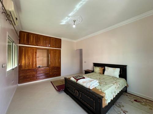 a bedroom with a bed and a dresser in it at الطابق الأول لفيلا مجهز بامتياز in Fez