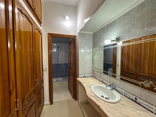 a bathroom with a sink and a mirror at الطابق الأول لفيلا مجهز بامتياز in Fez