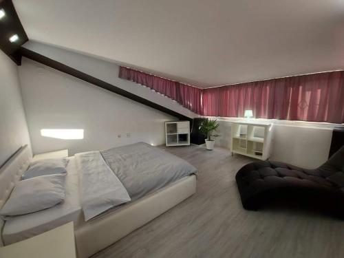 a bedroom with a large bed and a red curtain at Merter Apartments in Kavadarci