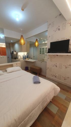 a large bedroom with two beds and a kitchen at Apartemen Patraland Urbano By Public Room in Bulanbulan