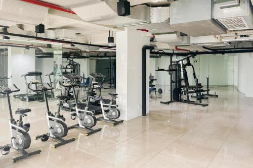 a gym with several rows of exercise bikes at Apartemen Patraland Urbano By Public Room in Bulanbulan