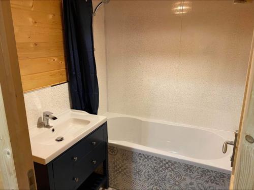 a bathroom with a sink and a bath tub at Inviting 2-Bedroom Cabin in Ashton Under Hill in Evesham