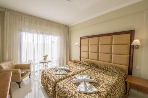 a hotel room with a bed with towels on it at Tsokkos Gardens Hotel in Protaras