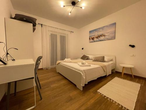 a bedroom with a bed and a table and a desk at Apartments TOM in Mimice