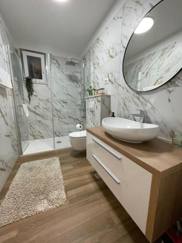 a bathroom with a sink and a tub and a mirror at Apartments TOM in Mimice