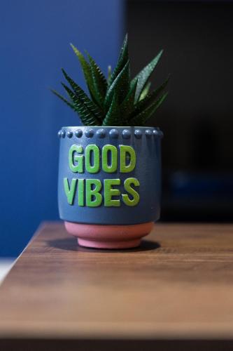 a plant in a pot with the words good vibes at Kirkview Apartment in Kirk of Shotts