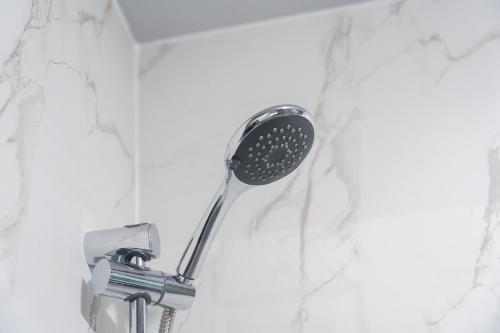 a shower head on a wall in a bathroom at Kirkview Apartment in Kirk of Shotts