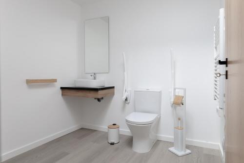 Un baño blanco con inodoro y lavabo. en Casa da Broa - Recantos d'Almerinda, en Alvito