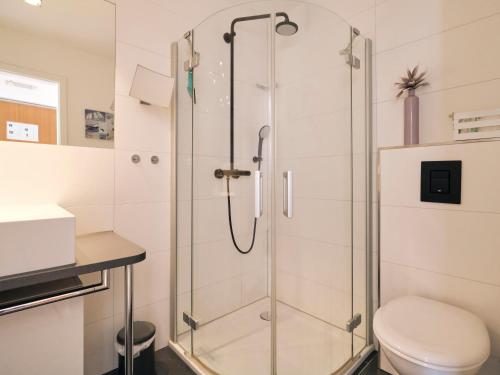 a glass shower in a bathroom with a toilet at Strandliebe in Harrislee