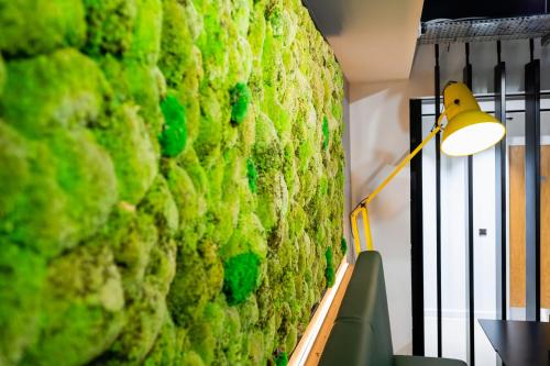 a lamp next to a wall with green moss at Staycity Aparthotels Liverpool Waterfront in Liverpool