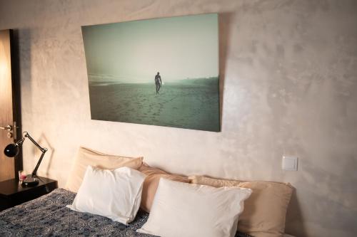 sypialnia z łóżkiem z obrazem na ścianie w obiekcie By the sea w Faro