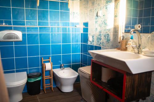 bagno piastrellato blu con lavandino e servizi igienici di By the sea a Faro