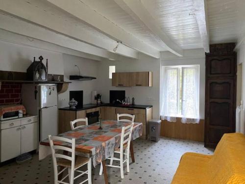eine Küche mit einem Tisch und Stühlen im Zimmer in der Unterkunft Dans une Cité de Caractère. in Jugon Les Lacs