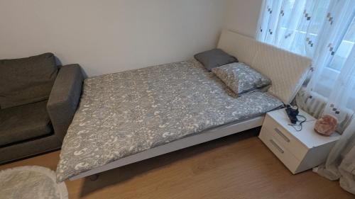 a small bedroom with a bed and a couch at Studio meublé pour 2 - Proche de Montreux in Montreux