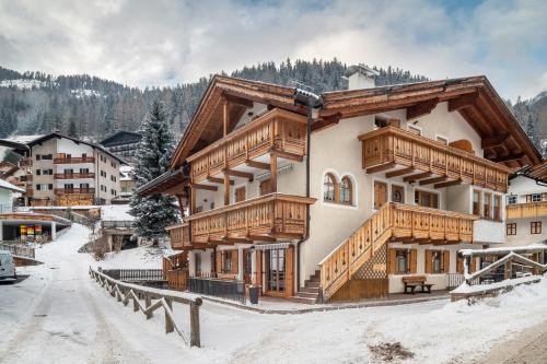 a large building with wooden balconies in the snow at Apartment Pordoi in Campitello di Fassa