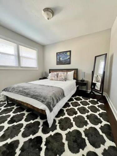 a bedroom with a large bed and a black and white rug at Gated 2BR Condo I 5 min Uptown in Charlotte