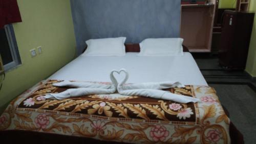a bedroom with a bed with a heart decoration on it at Hotel Swagat in Puri