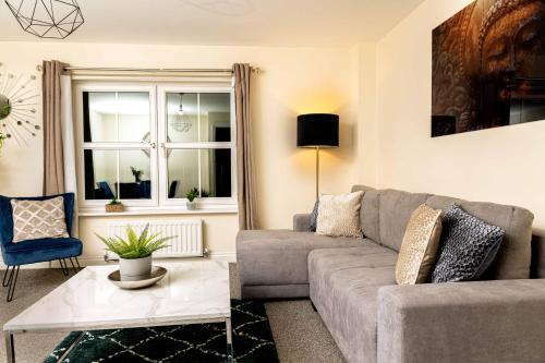 a living room with a couch and a table at Livingston North Station Apartments in Livingston