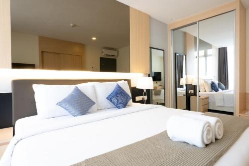 una camera da letto con un grande letto bianco e un grande specchio di Grand Ion Genting Highlands a Resorts World Genting