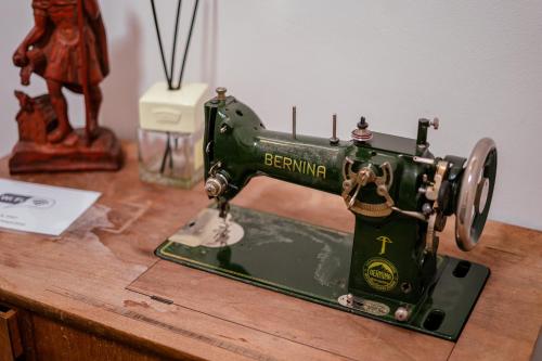 a green sewing machine sitting on top of a table at Ospizio La Veduta in Bivio