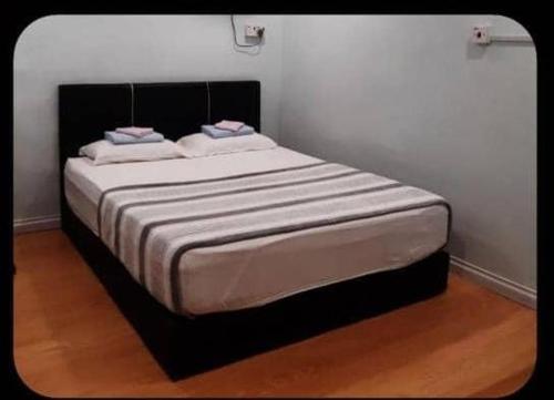 łóżko z 2 poduszkami w pokoju w obiekcie SC Lodging House Sinsuran Complex w mieście Kota Kinabalu