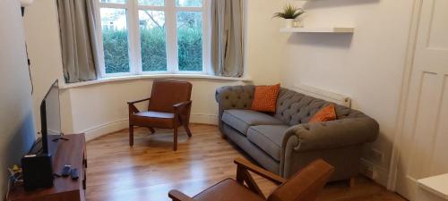 a living room with a couch and a chair at Spacious 3 bed House, Wolverhampton in Fallings Park